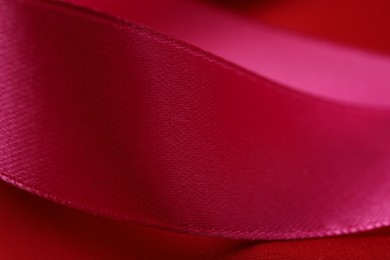 Beautiful crimson ribbon as background, closeup view
