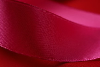 Photo of Beautiful crimson ribbon as background, closeup view