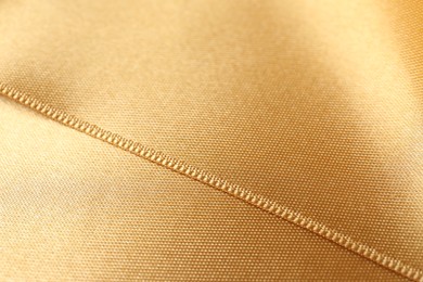 Beautiful golden ribbon as background, closeup view