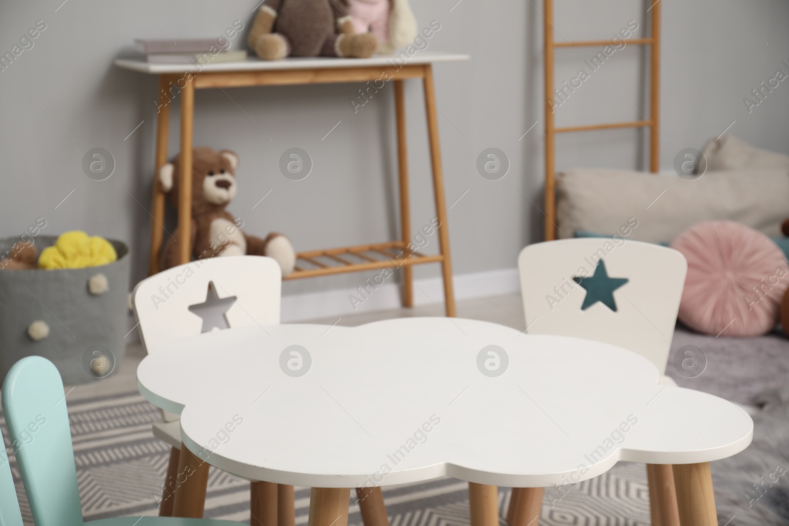 Photo of Stylish child room interior with table, chairs and toys