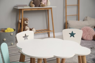 Stylish child room interior with table, chairs and toys