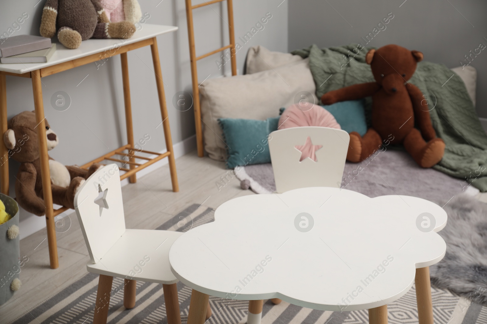 Photo of Stylish child room interior with table, chairs and toys