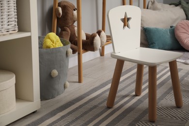 Small chair, teddy bear and pillows in child room. Interior design