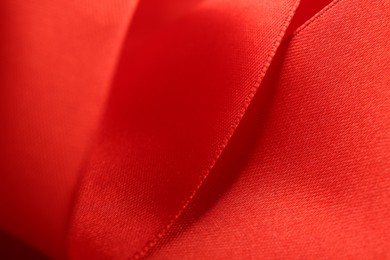 Beautiful red ribbon as background, closeup view