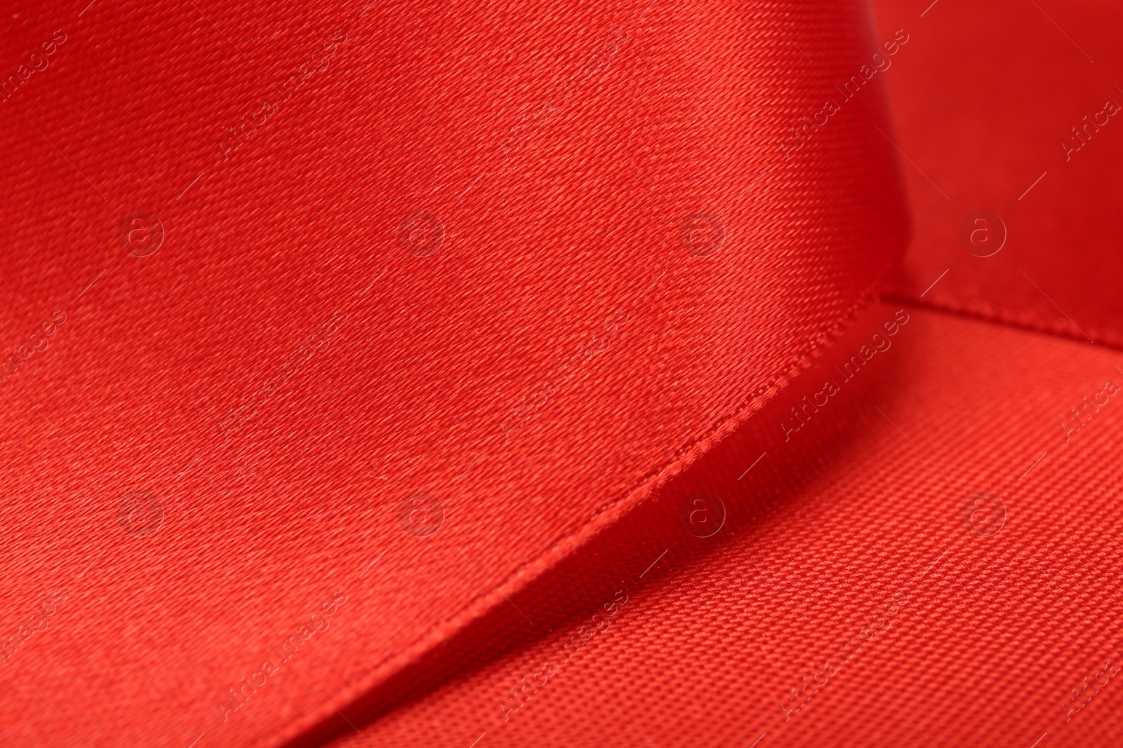 Photo of Beautiful red ribbon as background, closeup view