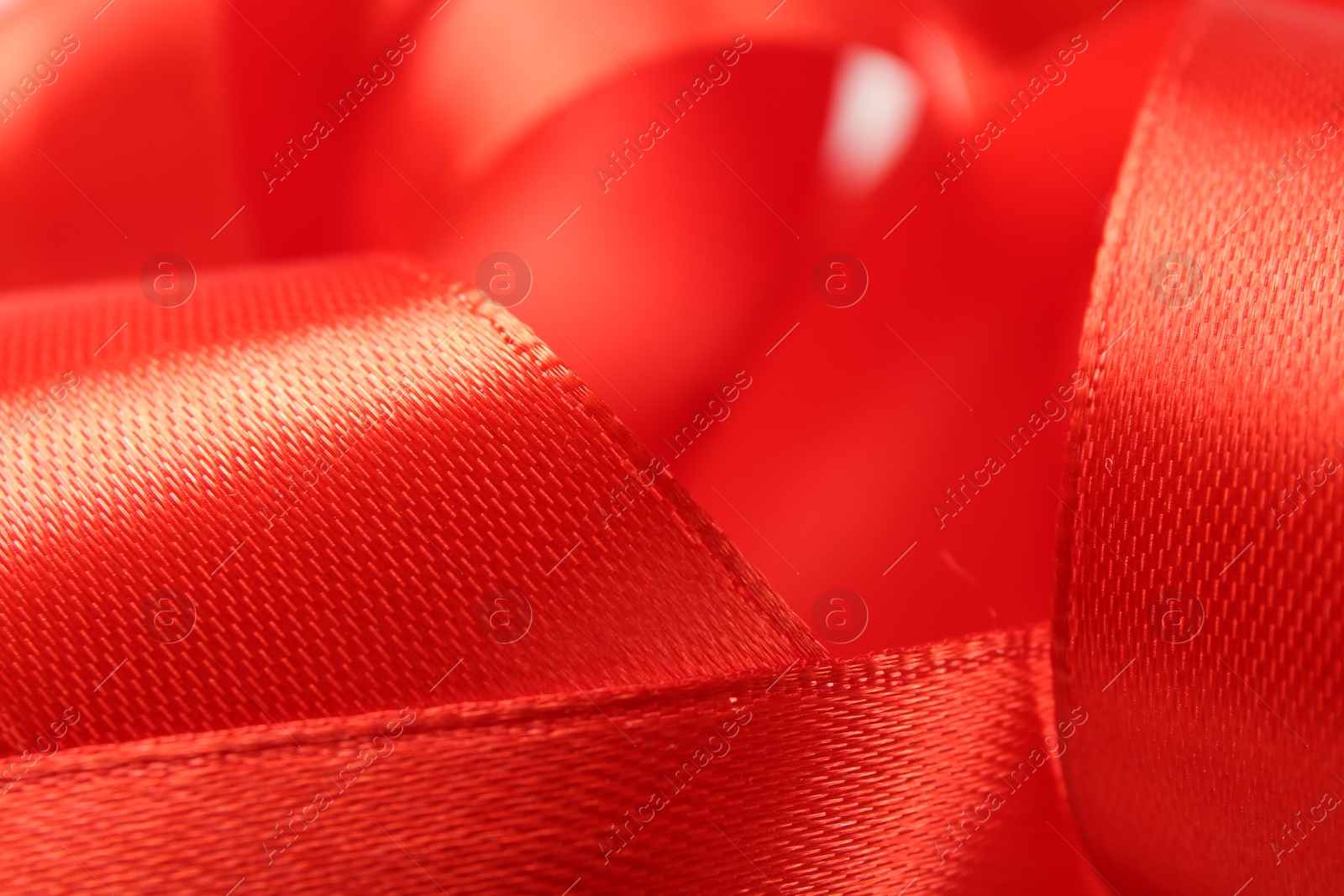 Photo of Beautiful red ribbon as background, closeup view