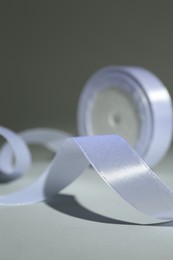 Beautiful white ribbon reel on gray background, closeup