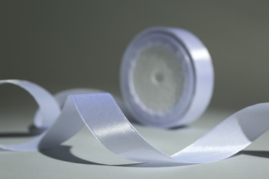 Beautiful white ribbon reel on gray background, closeup