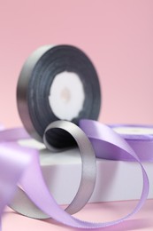 Ribbon reels in different colors on pink background, closeup view