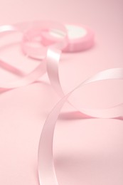 Photo of Beautiful ribbon reel on pink background, closeup