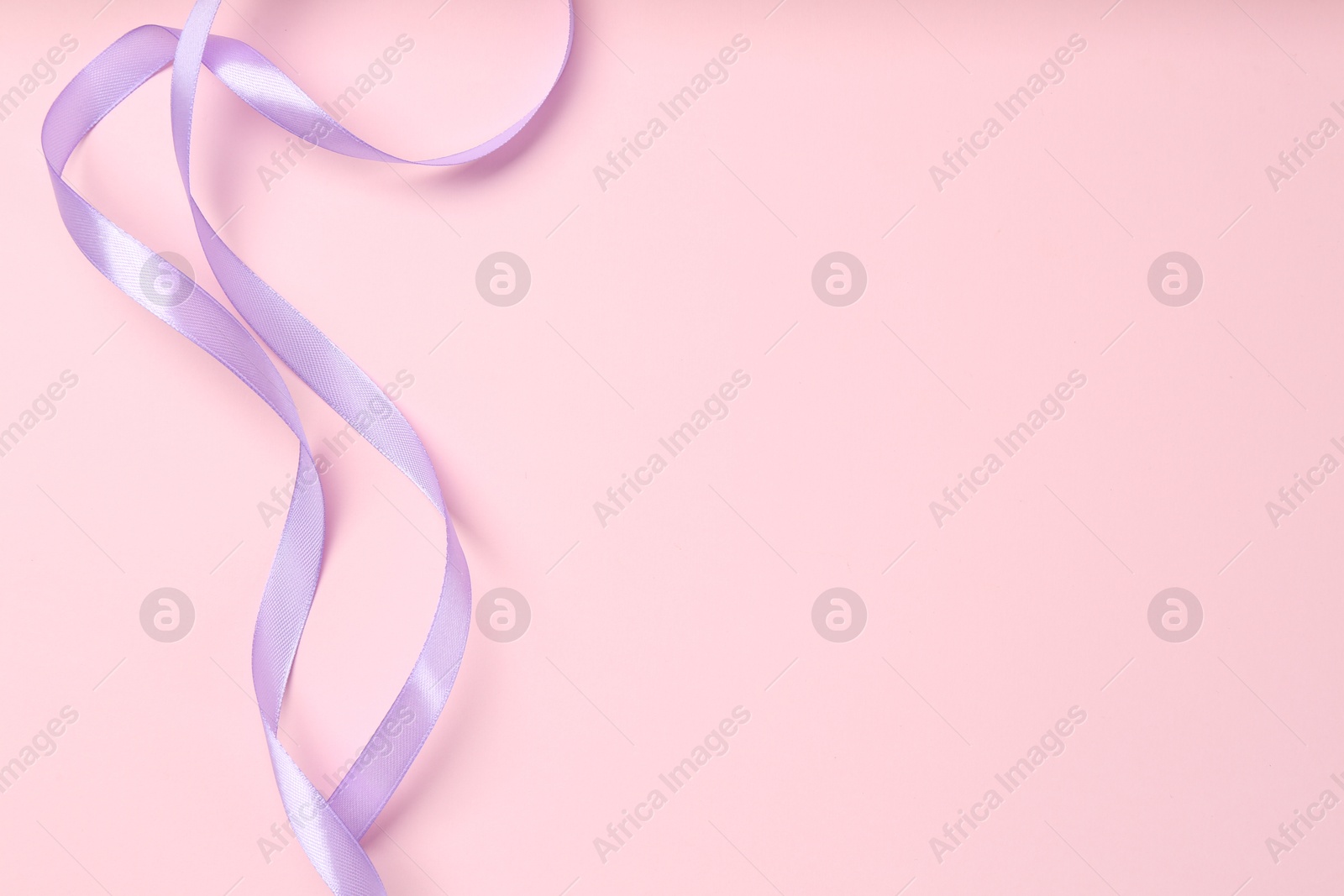 Photo of Beautiful violet ribbon on pink background, top view. Space for text
