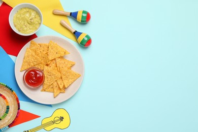 Flat lay composition with nachos chips and Mexican sombrero hat on light blue background, space for text