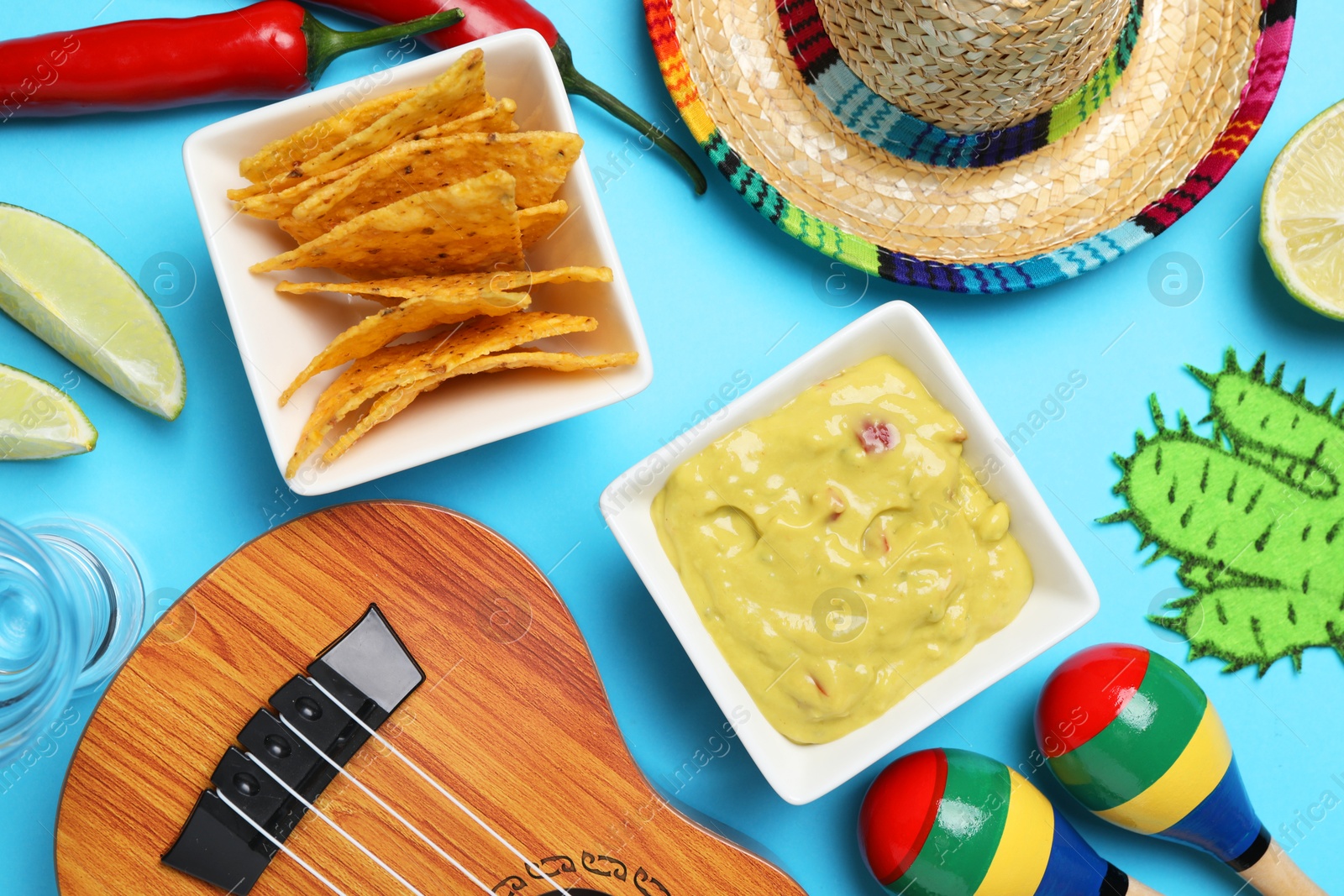 Photo of Flat lay composition with Mexican sombrero hat and guacamole on light blue background