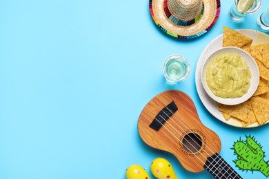 Photo of Mexican sombrero hat, ukulele, tequila, nachos chips, guacamole and maracas on light blue background, flat lay. Space for text