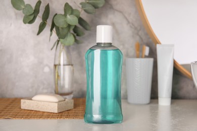 Photo of Bottle of mouthwash on light table in bathroom