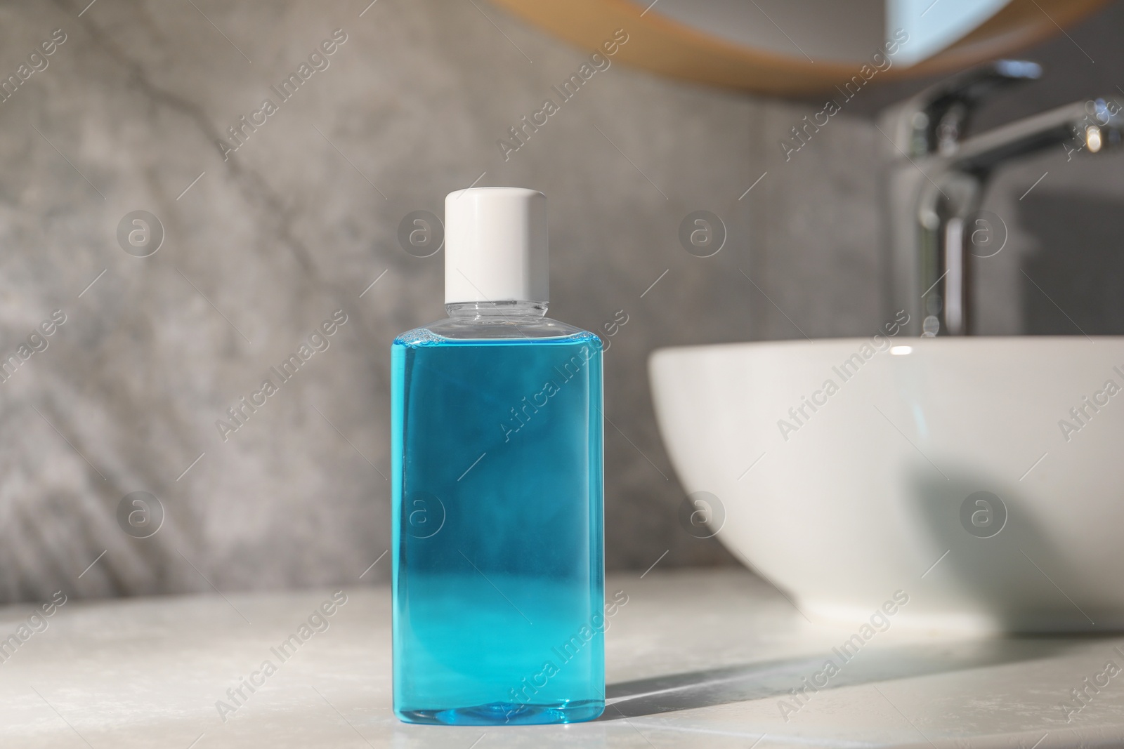 Photo of Bottle of mouthwash on light countertop in bathroom