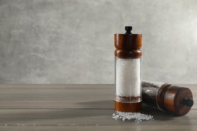 Photo of Salt and pepper shakers on wooden table, space for text