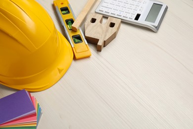 Photo of Building level and other construction tools on white wooden table, space for text