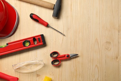 Flat lay composition with building level and other different construction tools on wooden background, space for text