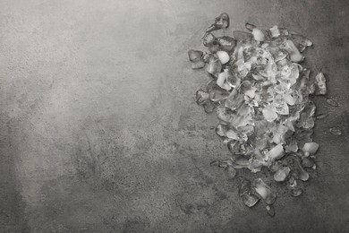 Photo of Pile of crushed ice on dark textured table, top view. Space for text