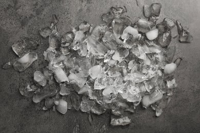 Photo of Pile of crushed ice on dark textured table, top view