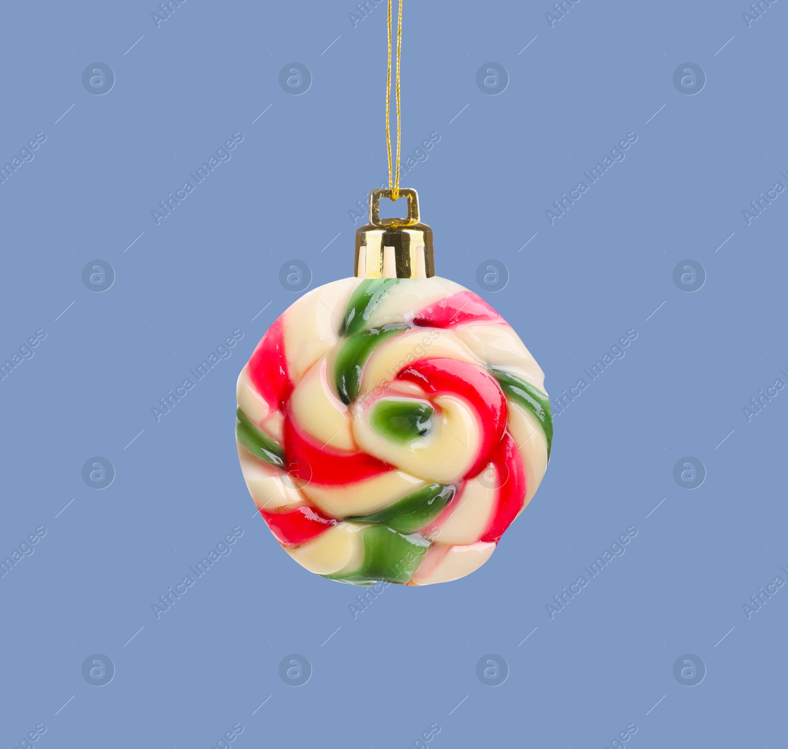 Image of Sweet candy with string like Christmas ball on pale blue background, creative collage