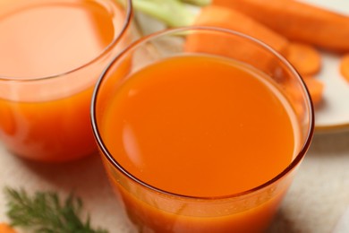 Photo of Healthy carrot juice in glasses on table, closeup