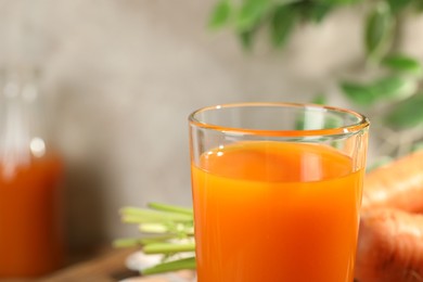 Healthy carrot juice in glass on table, closeup. Space for text