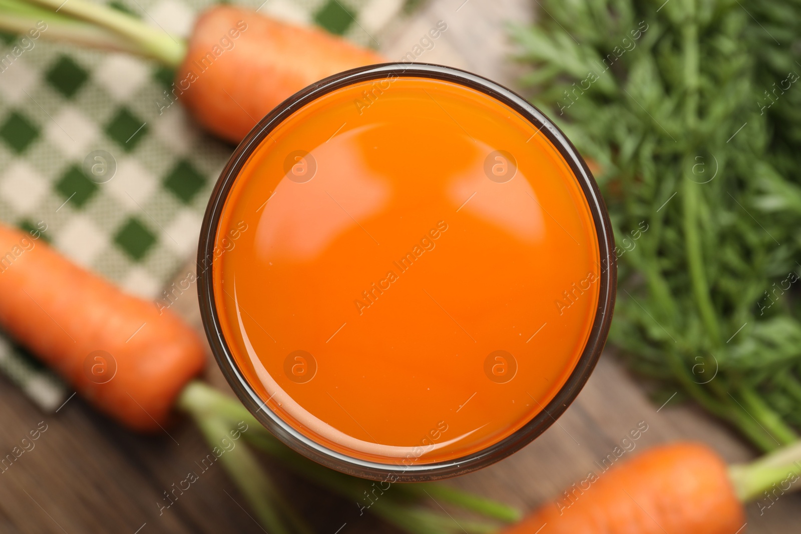 Photo of Healthy carrot juice in glass and fresh vegetables on table, top view