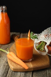 Photo of Healthy juice and fresh carrot on wooden table