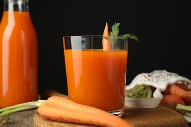 Healthy juice and fresh carrot on wooden table, closeup