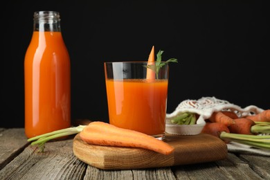 Healthy juice and fresh carrot on wooden table