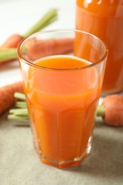 Healthy juice and fresh carrot on white wooden table, closeup