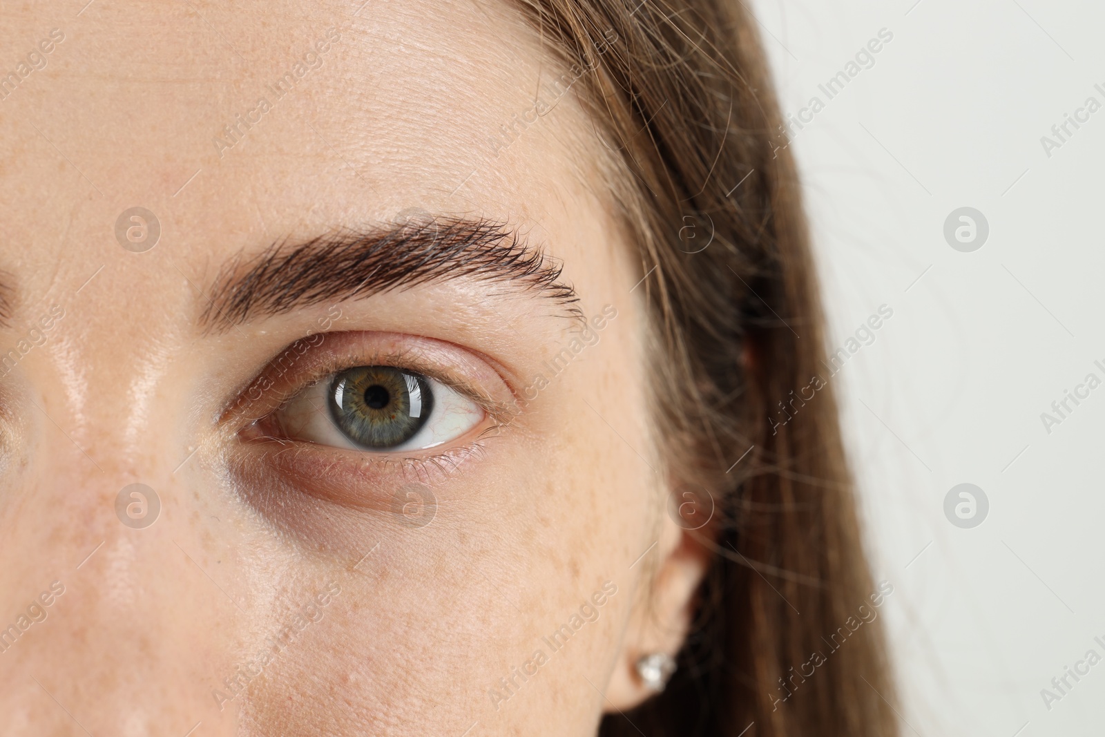 Photo of Closeup view of woman with beautiful eyes on light background