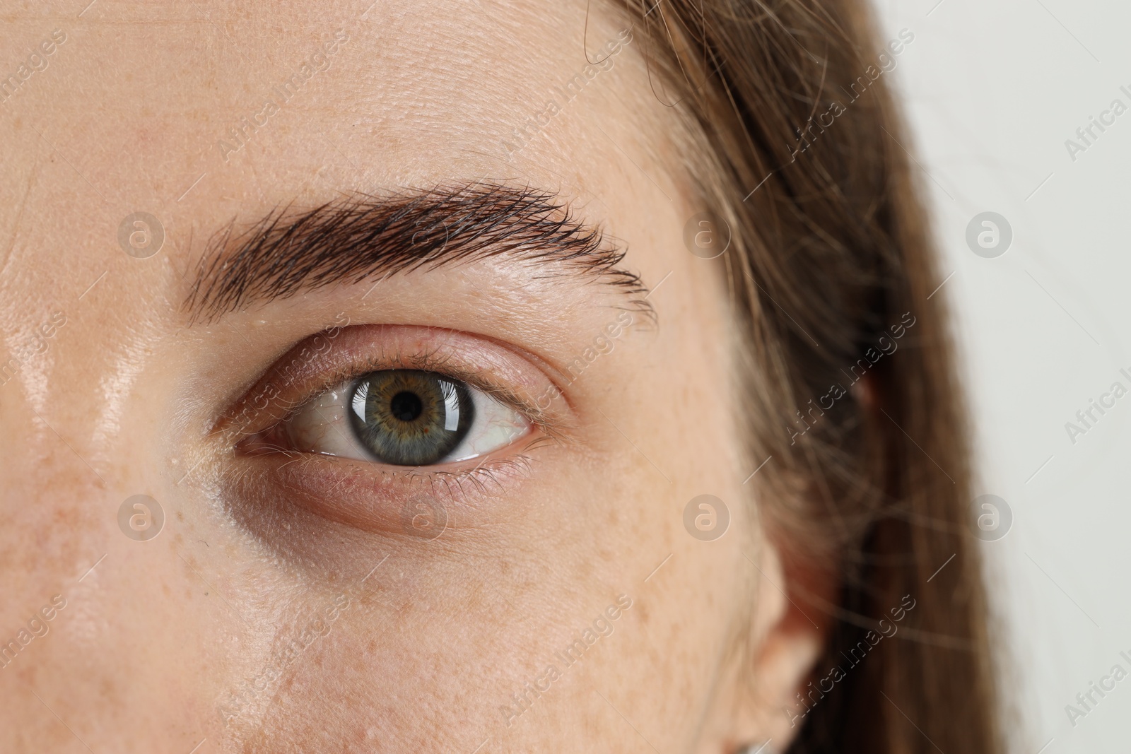 Photo of Closeup view of woman with beautiful eyes on light background