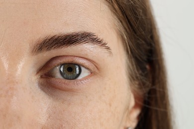 Photo of Closeup view of woman with beautiful eyes on light background