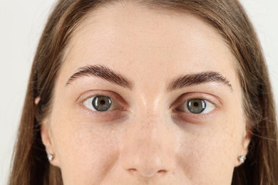 Photo of Closeup view of woman with beautiful eyes on light background