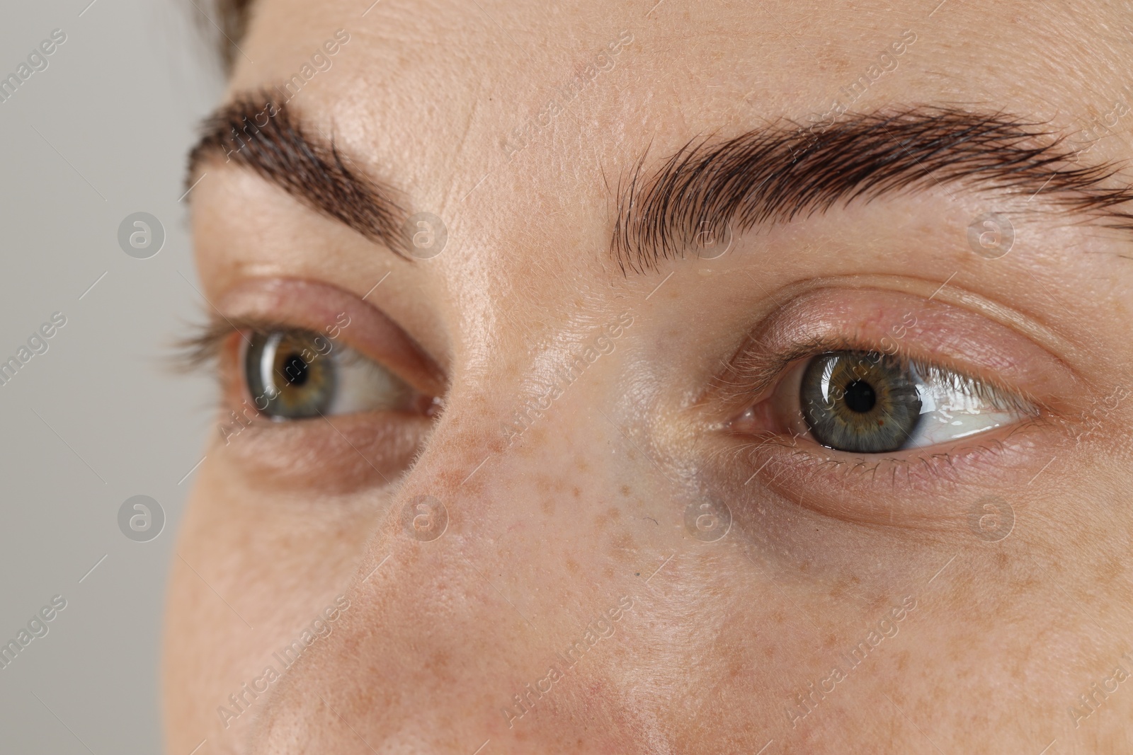 Photo of Closeup view of woman with beautiful eyes on light background