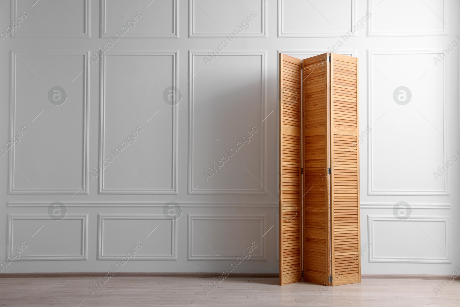 Photo of Folding screen near white wall indoors, space for text. Interior element