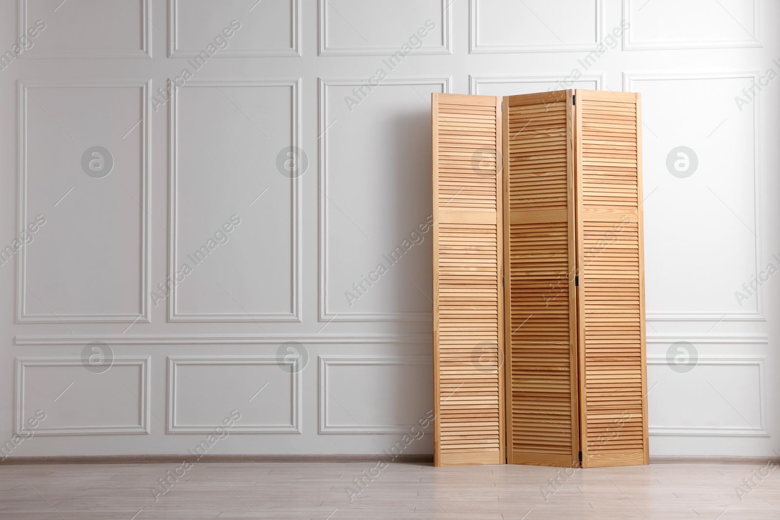 Photo of Folding screen near white wall indoors, space for text. Interior element