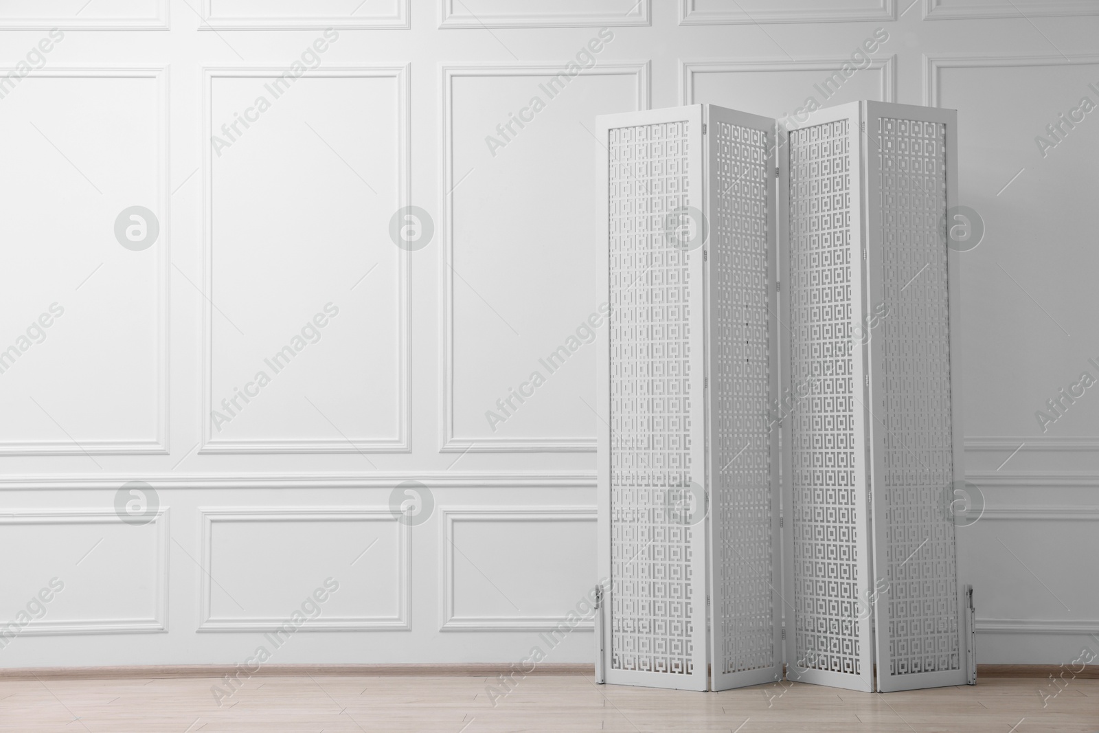 Photo of Folding screen near white wall indoors, space for text. Interior element