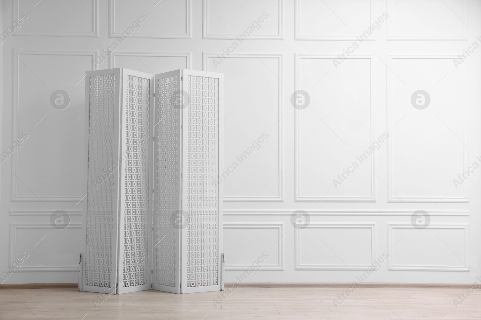 Photo of Folding screen near white wall indoors, space for text. Interior element