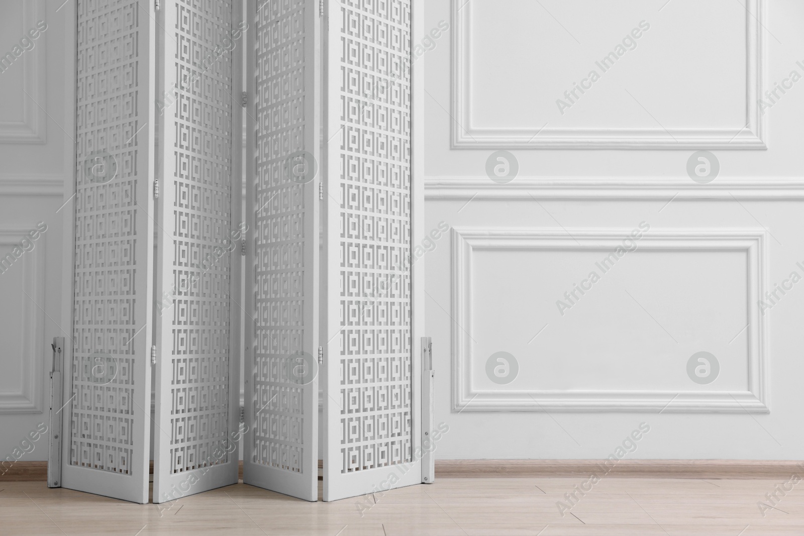 Photo of Folding screen near white wall indoors, space for text. Interior element