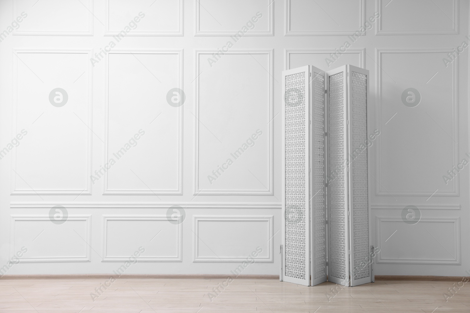 Photo of Folding screen near white wall indoors, space for text. Interior element