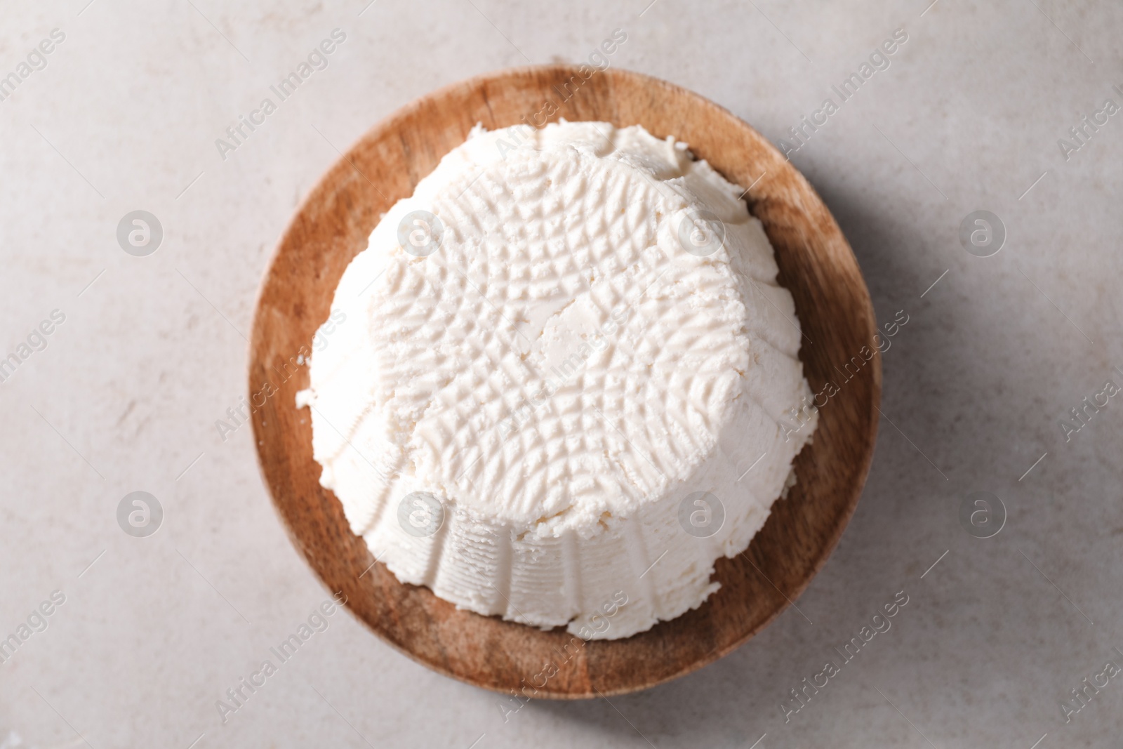 Photo of Fresh ricotta (cream cheese) on light grey table, top view