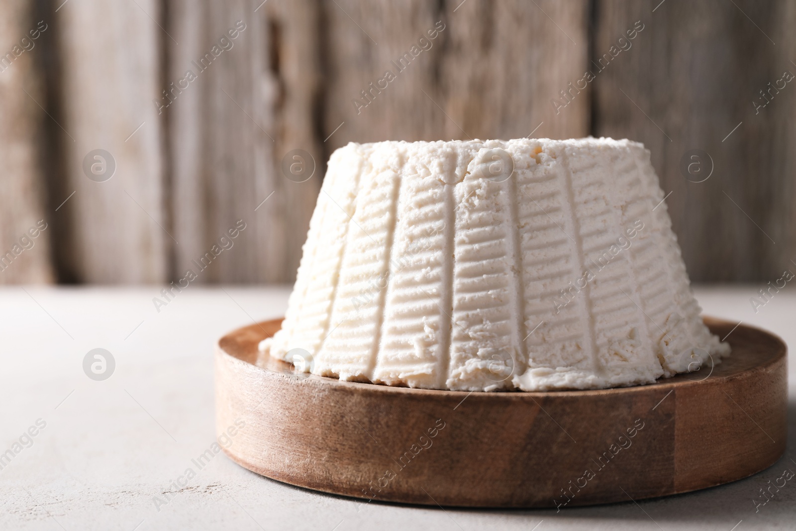 Photo of Fresh ricotta (cream cheese) on light grey table, closeup