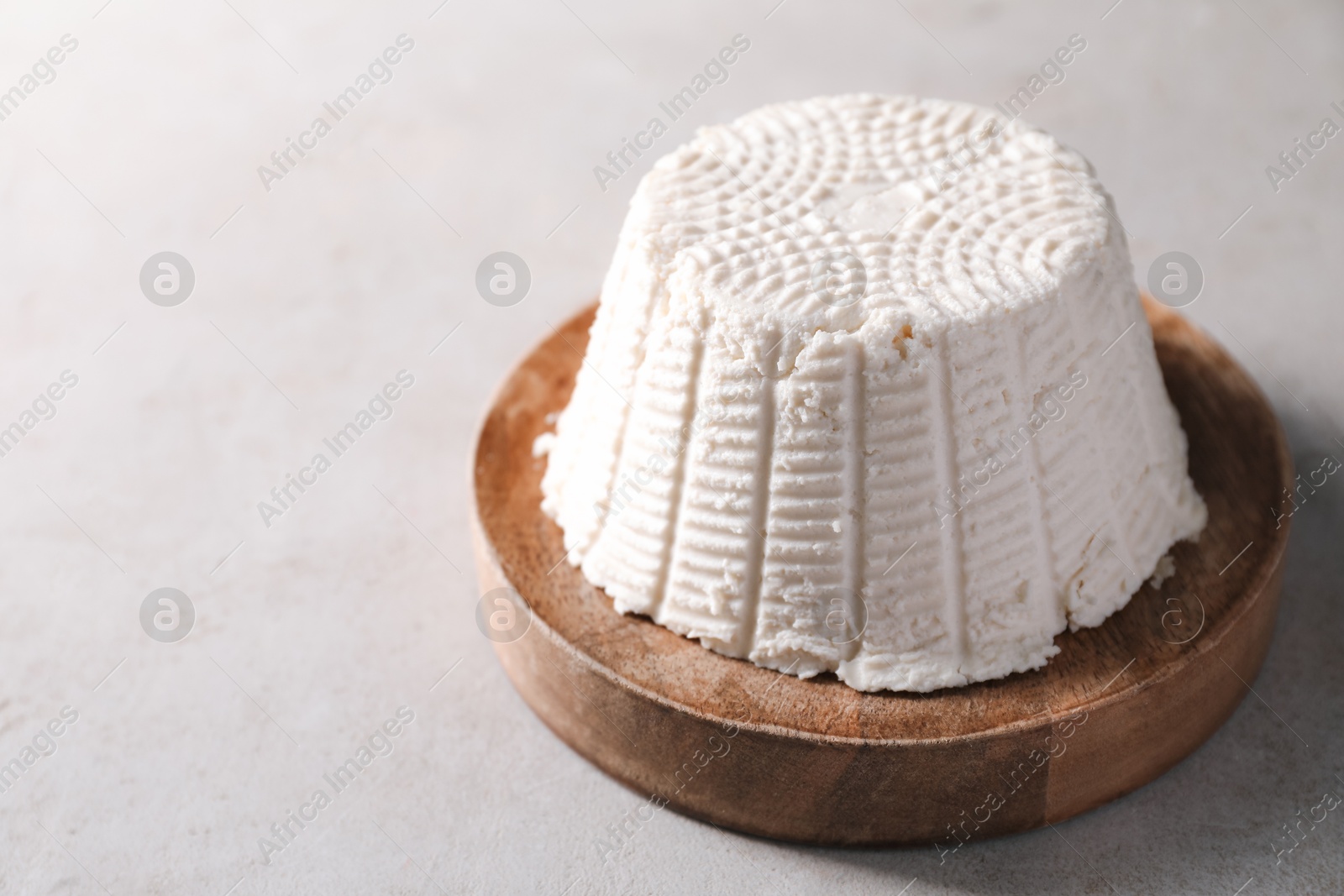 Photo of Fresh ricotta (cream cheese) on light grey table, space for text