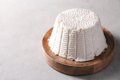 Fresh ricotta (cream cheese) on light grey table, space for text