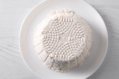 Fresh ricotta (cream cheese) on white wooden table, top view