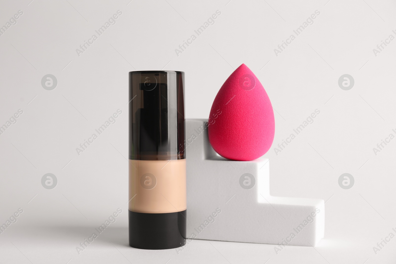 Photo of Makeup sponge and skin foundation on light grey background